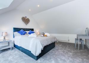 a bedroom with a large bed with blue pillows at Tyisaf in Llanfynydd