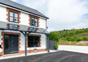 Casa blanca con ventanas negras y entrada en Tyisaf en Llanfynydd
