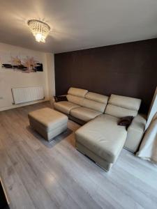a living room with a couch and two ottomans at Beautiful 4 bedroom home with private parking in West Thurrock