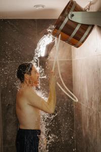 Ein Mann spielt mit einem Wasserschlauch in der Dusche in der Unterkunft Sporthotel Kurz in Oberpullendorf