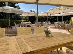 une table et des chaises en bois avec des parasols blancs dans l'établissement Dötlinger Hof, à Dötlingen