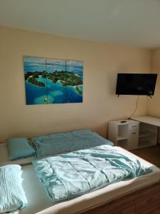 ein Schlafzimmer mit einem Bett mit zwei Gemälden an der Wand in der Unterkunft Onkel Tom Amazonien & Ozeanien in Paderborn