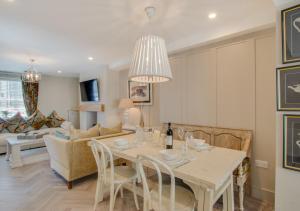 a dining room and living room with a table and chairs at Mulberry Cottage in Conwy