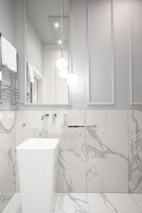 bagno bianco con lavandino e specchio di RentPlanet - Apartamenty Stare Miasto a Breslavia