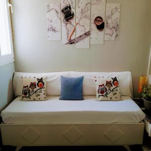 a white couch with pillows on it in a room at Sabbia Calda 7 in Perissa