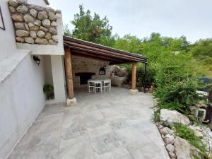 an outdoor patio with a table and a fireplace at Villa Rico Masseria nel Parco in Caramanico Terme