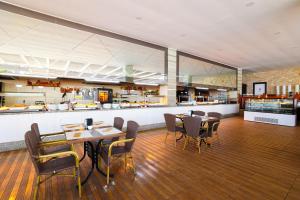 ケメルにあるCrystal Aura Beach Resort & Spa - Ultimate All Inclusiveのテーブルと椅子のあるレストラン、キッチンが備わります。
