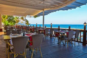 a restaurant on the beach with tables and chairs at Crystal Aura Beach Resort & Spa - Ultimate All Inclusive in Kemer