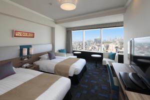 a hotel room with two beds and a large window at Shibuya Excel Hotel Tokyu in Tokyo