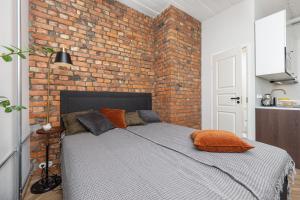 Un dormitorio con una pared de ladrillo y una cama en Peetri Apartments, en Tartu
