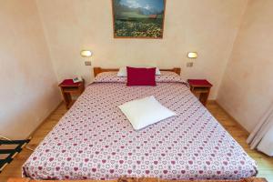 una camera da letto con un grande letto con una coperta rossa e bianca di Albergo Adele a Bormio
