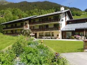 a large building with a garden in front of it at Appartement calme 4 pers, pied des pistes avec parking - FR-1-342-160 in Arêches