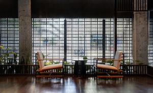 バンコクにあるBeanstalk Bangkokの大きな窓の前に椅子2脚が備わる客室です。