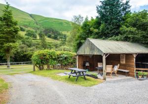 a wooden cabin with a picnic table and a picnic bench at Y Felin in Machynlleth
