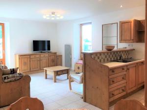 a kitchen with wooden cabinets and a tv in it at Appartement confortable et lumineux, 66m², 2 chambres, 5 personnes, Beaufort – Wifi inclus, proche services - FR-1-342-228 in Beaufort +7 photos
