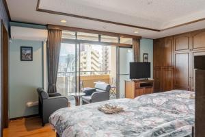 ein Hotelzimmer mit einem Bett und einem großen Fenster in der Unterkunft Residence Ferie Nara station in Nara
