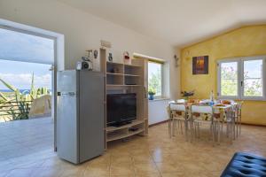 cocina y comedor con nevera y mesa en Villa Sole en Tertenìa