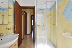 W łazience znajduje się szklana kabina prysznicowa i umywalka. w obiekcie Villa Sole w mieście Tertenìa