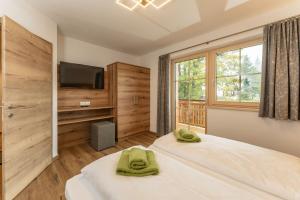 sypialnia z dwoma łóżkami i telewizorem z płaskim ekranem w obiekcie Appartements Die Ramsauerin w mieście Ramsau am Dachstein