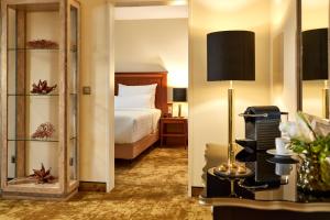 a hotel room with a bed and a mirror at Das Carls Hotel in Düsseldorf +47 photos