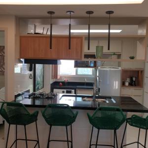 a kitchen with green chairs and a counter top at Ponta Negra RN02 in Natal
