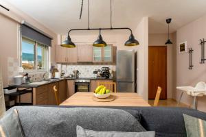 uma cozinha com uma mesa com uma tigela de bananas em Eleni's modern apartment em Volos