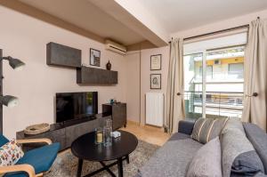 a living room with a couch and a tv at Eleni's modern apartment in Volos