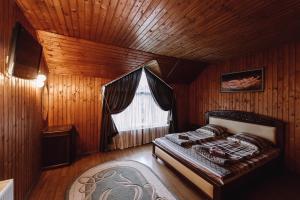 um quarto com uma cama num quarto de madeira em Toga em Yablunytsya