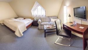 a small hotel room with a bed and a desk at Landhaus Wolf - wir freuen uns in Schwäbisch Hall