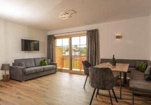 salon z kanapą i stołem w obiekcie Appartements Die Ramsauerin w mieście Ramsau am Dachstein