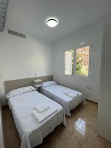 2 łóżka w białym pokoju z oknem w obiekcie Casa Blanca w Murcji