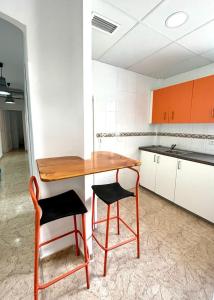 a kitchen with a wooden table and two chairs at Casa Blanca in Murcia