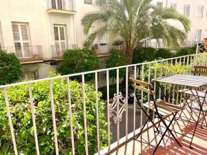 a balcony with a table and chairs and a palm tree at Casa Blanca in Murcia