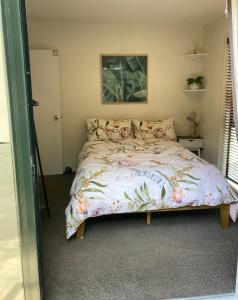 a bedroom with a bed with a floral bedspread at City Stay in Christchurch