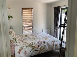 a bedroom with a bed with a floral comforter at City Stay in Christchurch