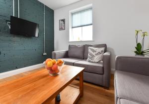 a living room with a couch and a bowl of fruit on a table at Geufron House in Aberdaron