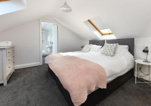 a bedroom with a bed and a dresser and a mirror at Geufron House in Aberdaron