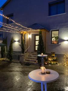 a patio with two tables in front of a house with lights at Gästehaus Schattemorellsche 