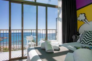 a bedroom with a view of the ocean from a balcony at Casual Pop Art Benidorm in Benidorm