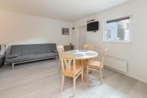a living room with a table and chairs and a couch at Apartments Berni in Ljubljana