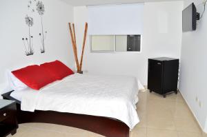 sypialnia z łóżkiem z czerwoną poduszką w obiekcie Hotel D' Leon Inn w mieście Aguachica