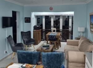 sala de estar con sofá, mesa y sillas en Marina Sands 13A, en Jeffreys Bay