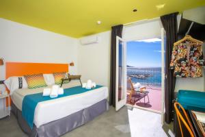a bedroom with a bed and a balcony with a view at Casual Pop Art Benidorm in Benidorm