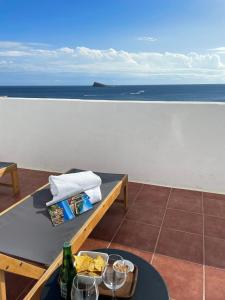 a table with some wine glasses and a view of the ocean at Casual Pop Art Benidorm in Benidorm