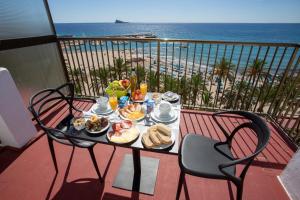 einen Tisch mit Frühstück auf einem Balkon mit Strandblick in der Unterkunft Casual Pop Art Benidorm in Benidorm