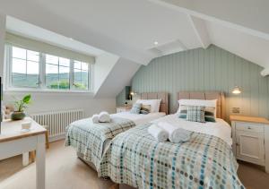 two beds in a bedroom with two windows at Esgair Wen in Pentre-briwnant