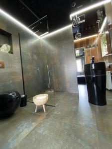 a bathroom with a shower and a stool in a room at LUKSUSOWE Waikiki w Krainie Alicji in Ełk