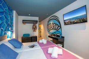 a bedroom with a large white bed and a tv on the wall at Casual Pop Art Benidorm in Benidorm