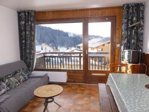 sala de estar con sofá y ventana grande en Appartement Notre-Dame-de-Bellecombe, 2 pièces, 6 personnes - FR-1-595-20 en Notre-Dame-de-Bellecombe