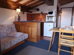 a kitchen with a couch and a table in a room at Studio calme à Notre-Dame-de-Bellecombe pour 4 personnes avec parking - FR-1-595-28 in Notre-Dame-de-Bellecombe +6 photos